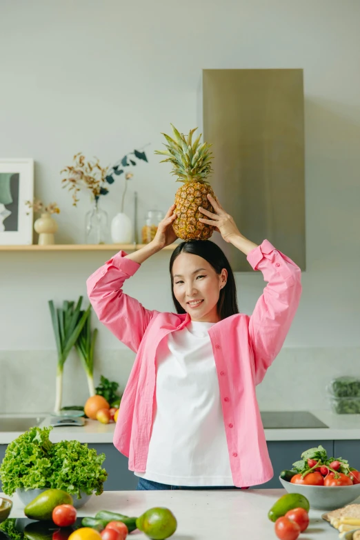 a woman in pink shirt with pineapple on her head