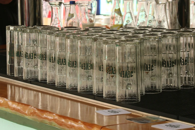 several empty glasses sit on a bar with price tags