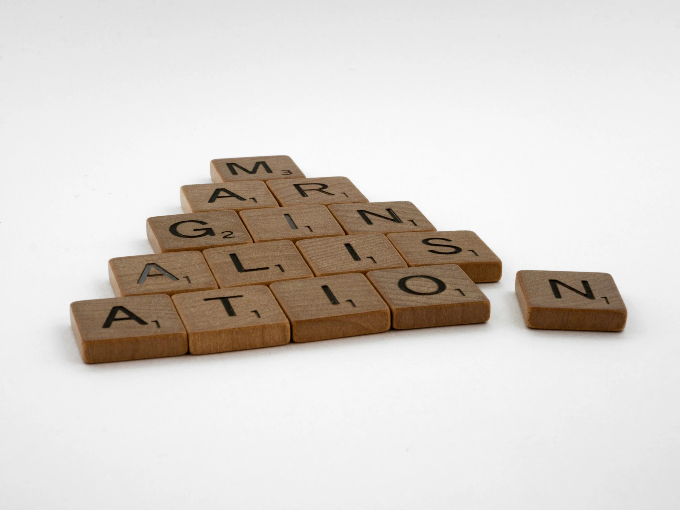 the word genius spelled with scrabbles arranged in the shape of triangle