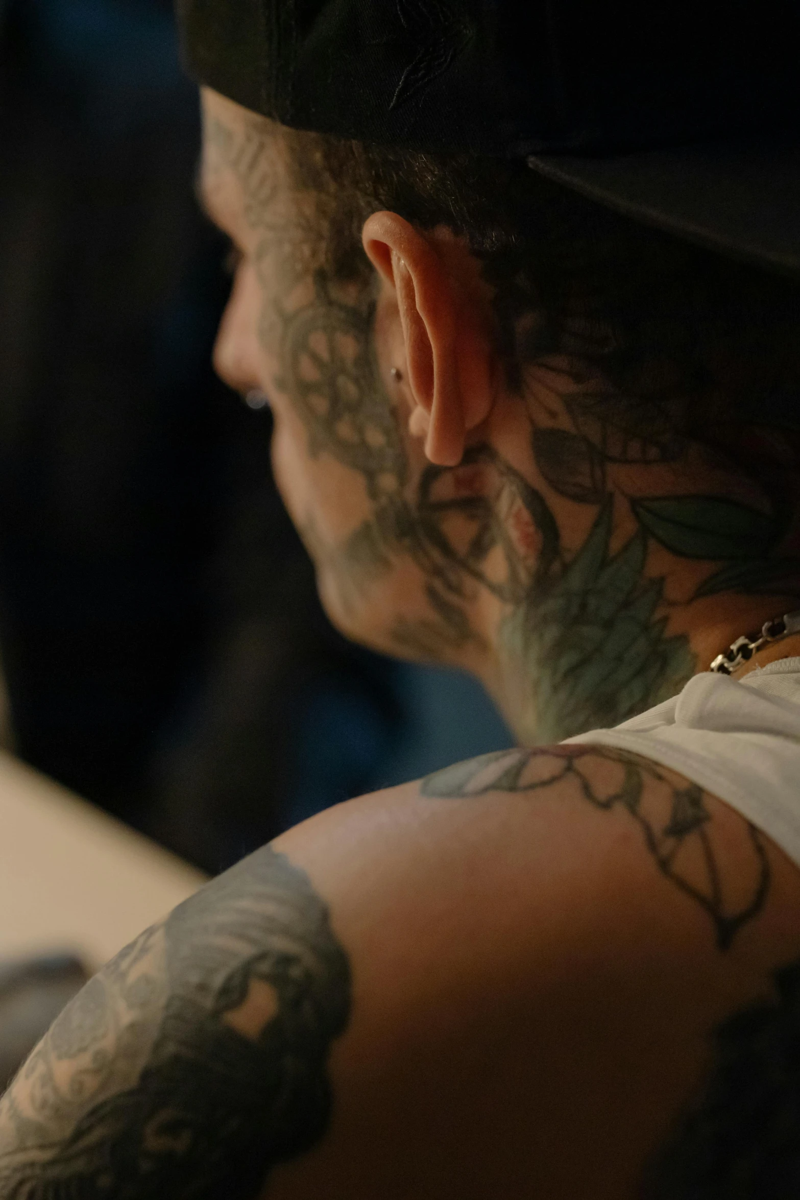 a man with tattoos and a hat is staring at soing