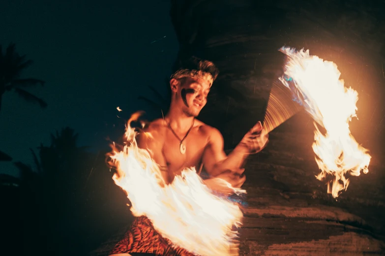 a man holding fire torches posing for a picture