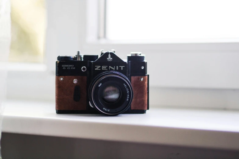 a camera sitting on a window sill with a window sill in the background