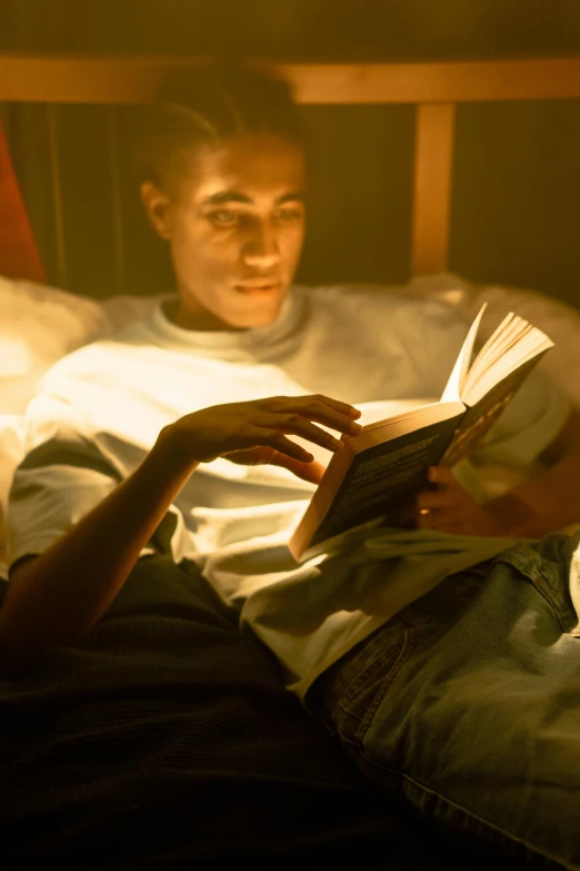 a person laying in bed reading a book