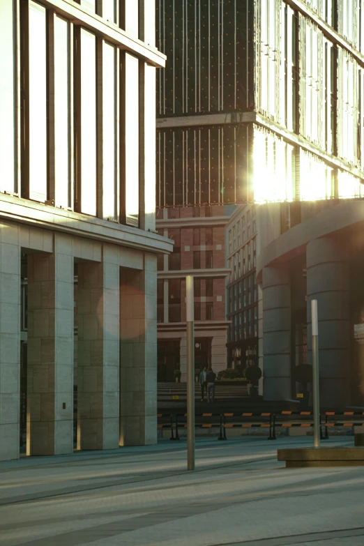 sun shining on tall buildings near a square