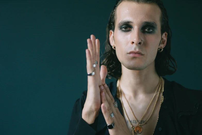 a woman wearing long hair and face jewelry with her hands together