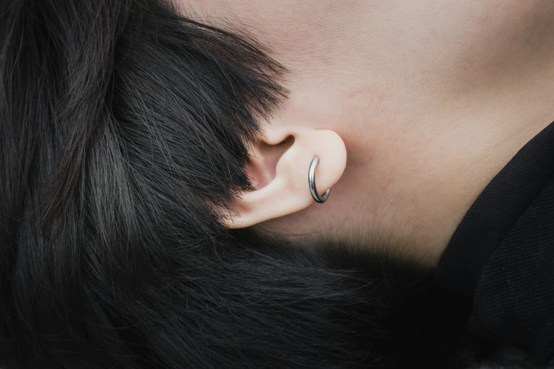 a woman's ear has a small circular object attached to it