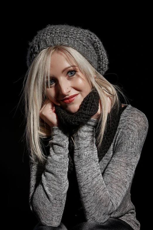 a woman is smiling while wearing a hat and gloves