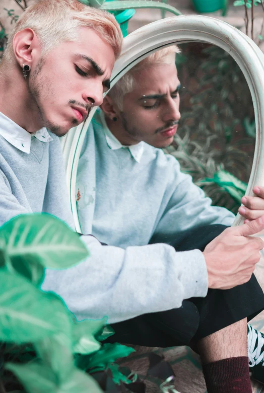 two men who are looking in a mirror