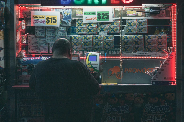 a man sitting in front of a vending machine