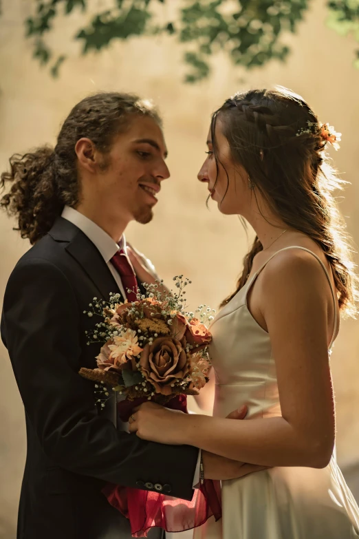 young couple holding flowers while smiling for each other