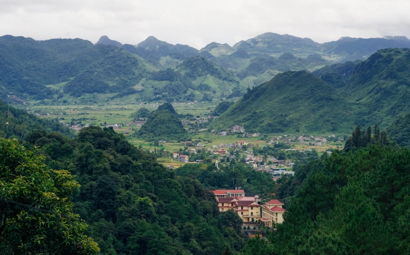 an aerial view of a mountain town surrounded by lush trees