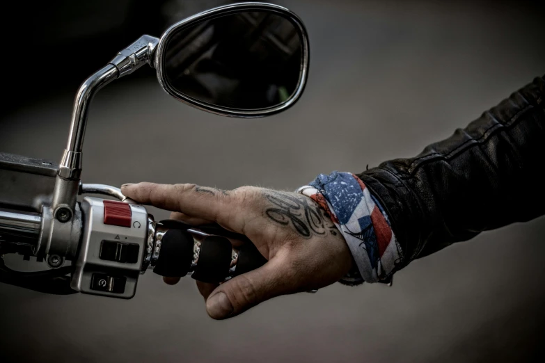 a man's hand holding a motorcycle handlebar