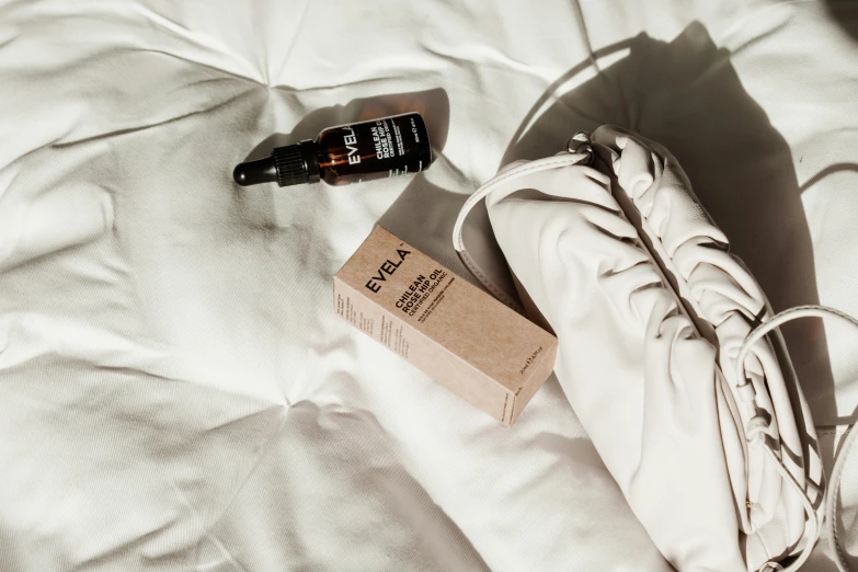 an empty bag laying on the bed next to a bottle of dot dot dot