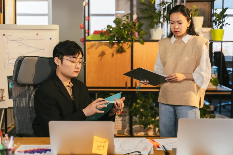 two employees standing in a room looking at files