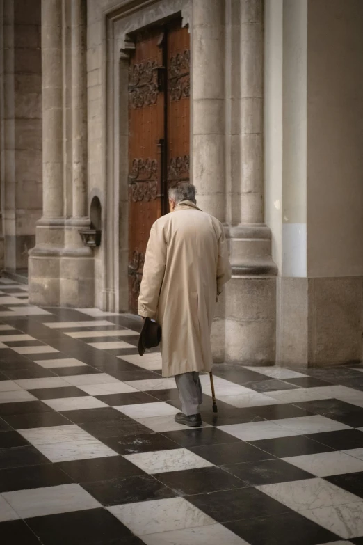 a person with a coat on standing in front of a door