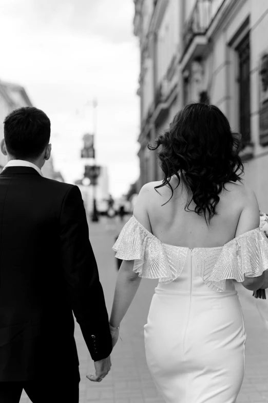 a couple walking down the street holding hands