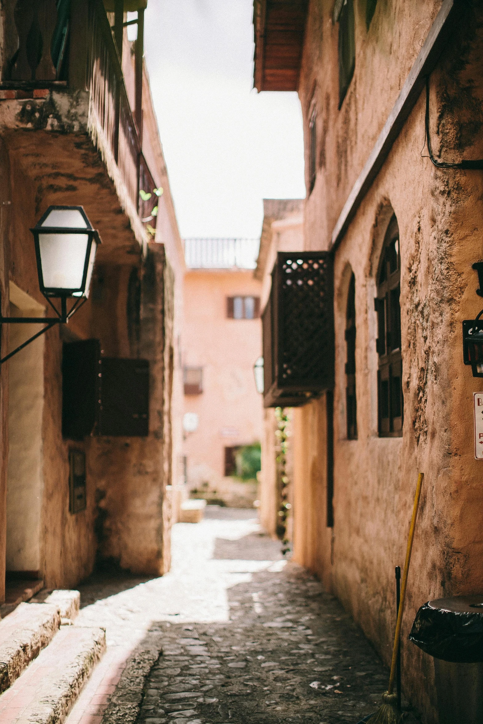 a light post stands on an alley between two buildings