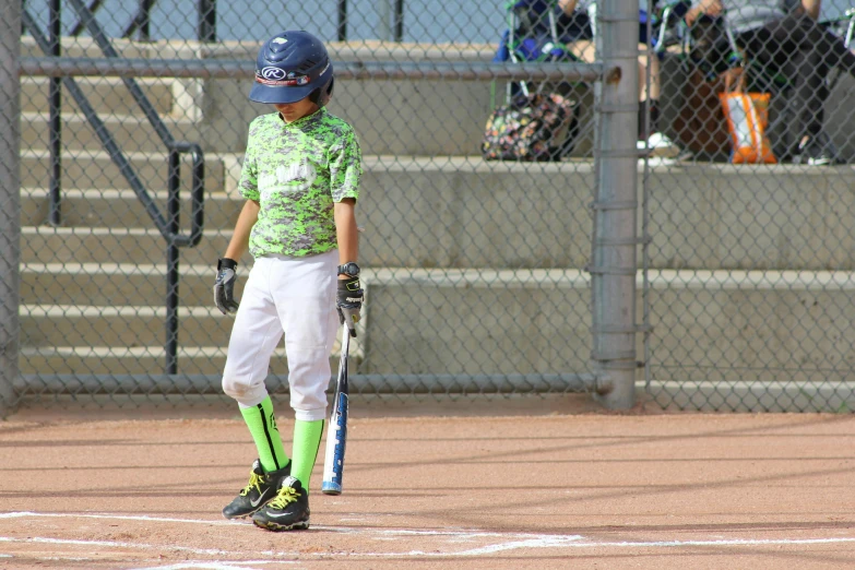 a small boy wearing a baseball uniform and holding a bat