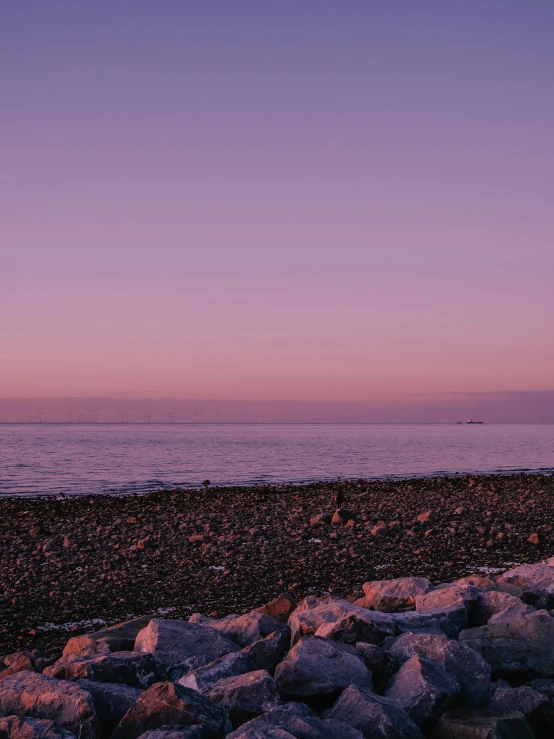 a large body of water sitting below a purple sky