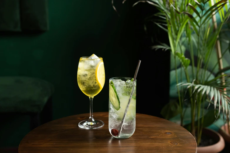 two glasses filled with drinks are sitting on the table