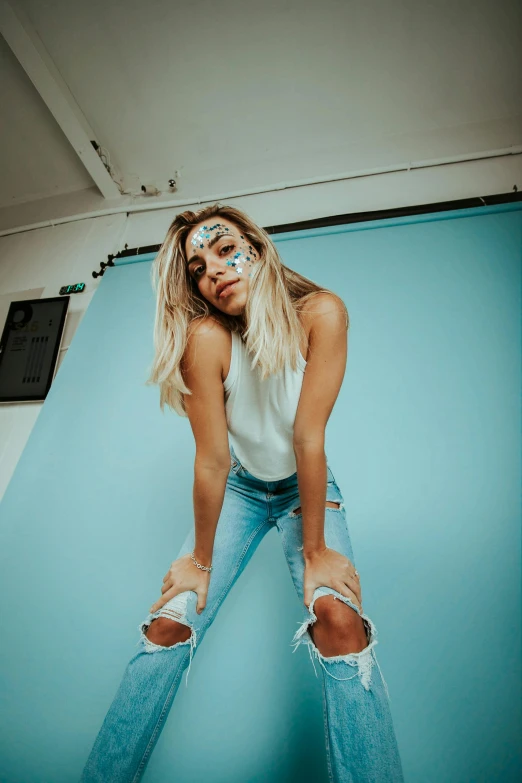 a woman standing in ripped jeans on the floor