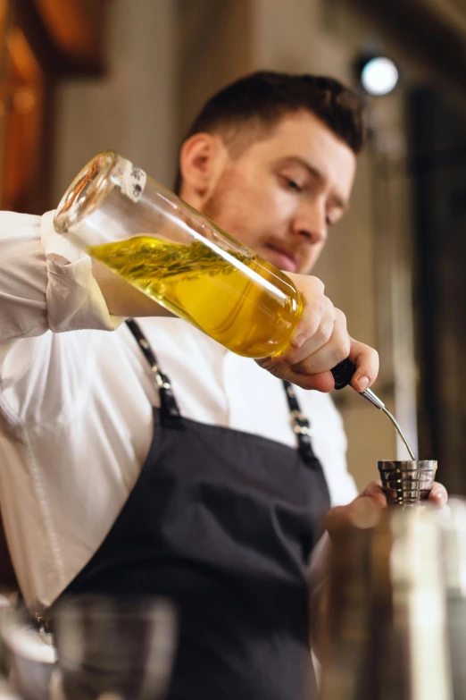 a man preparing some drinks with a spoon