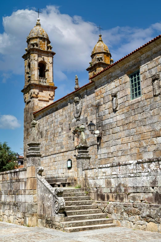 old wall with stairs leading to a bell tower and two towers