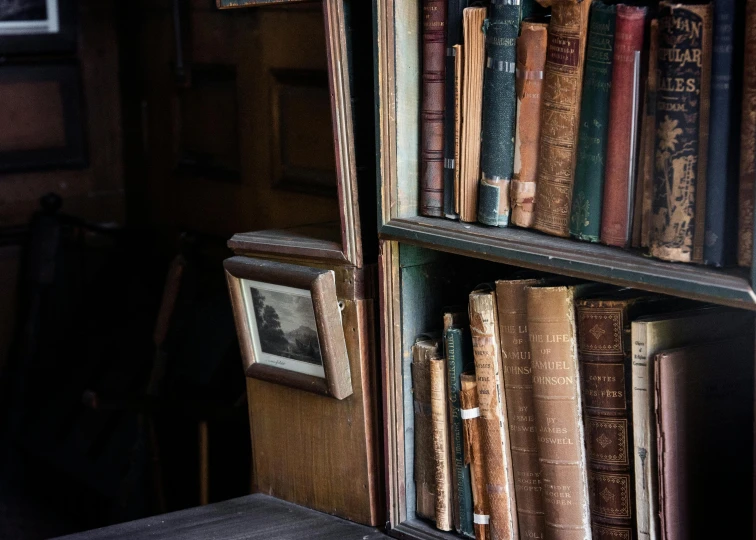 a bookcase filled with books in front of a window