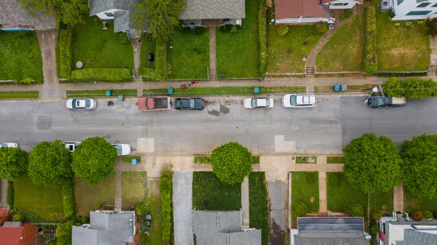 a view from above of a road, trees and vehicles