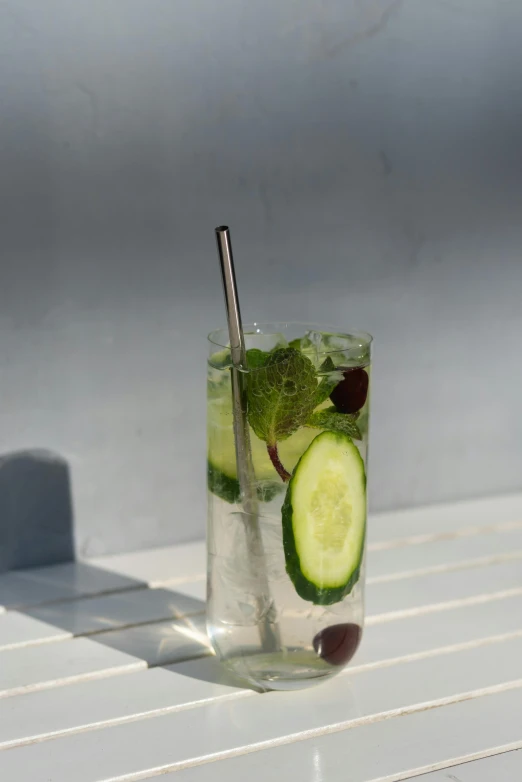 the glass with cucumbers is sitting on the table