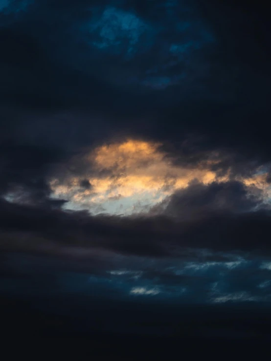 clouds with blue and yellow colors under a very dark sky