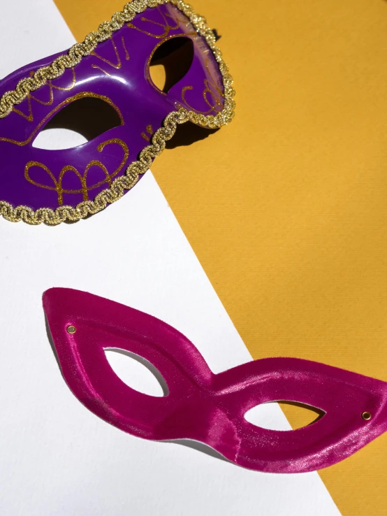 purple mask next to a purple masquerade on yellow and white papers