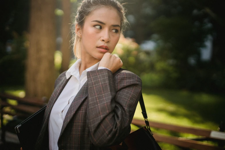 woman standing in the middle of a wooded area, in business attire