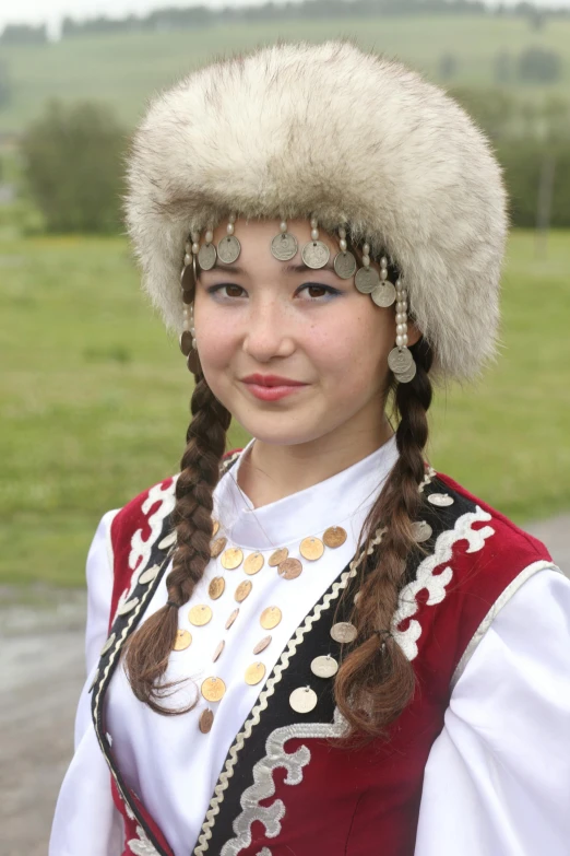 a woman wearing a head piece and long ids smiles