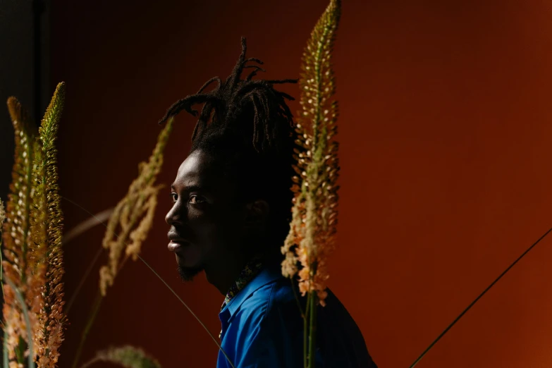 a man with dread locks looking at the grass