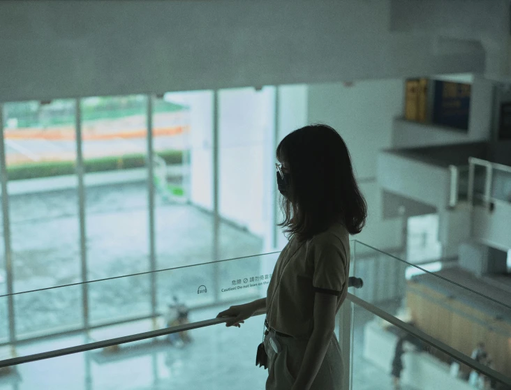 a  is looking out the glass balcony