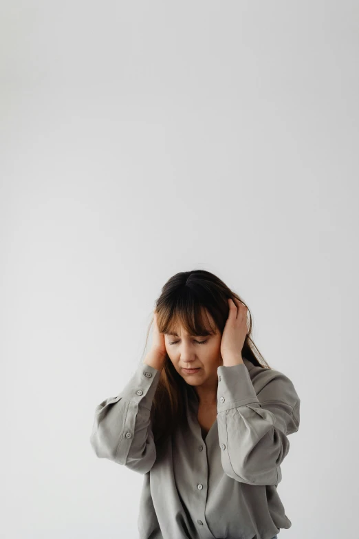 a woman sitting on a bed holding her head in her hands