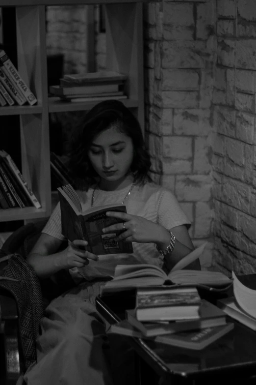 two people sit in a liry with books on a table