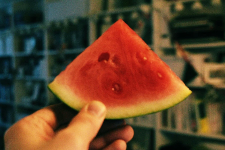 a watermelon slice being held by someone