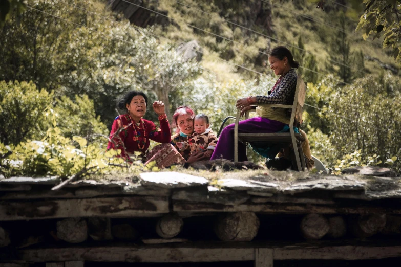 a group of women sitting on top of a wooden bench