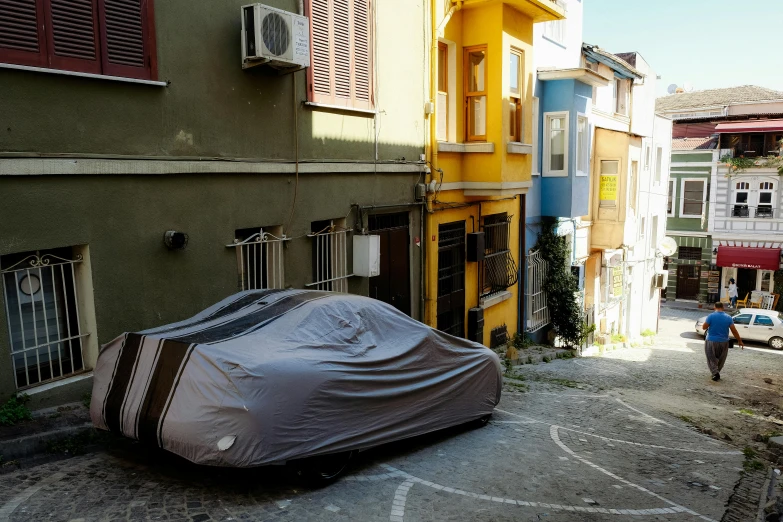 a covered car is parked on the side of a street