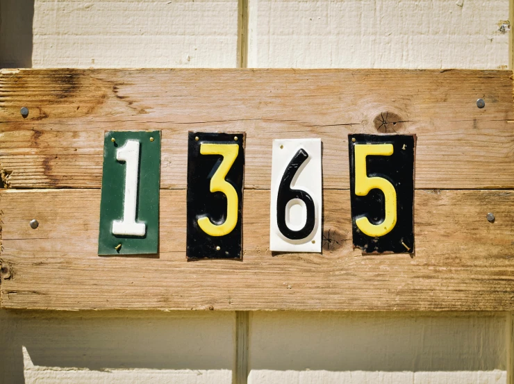 the wooden wall sign has numbers displayed on it