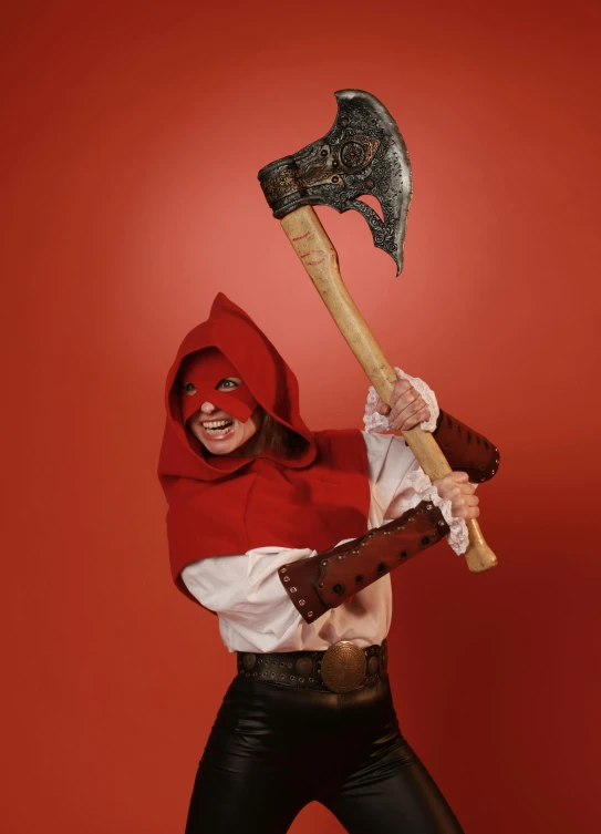 a woman wearing leather pants and mask with a huge axe