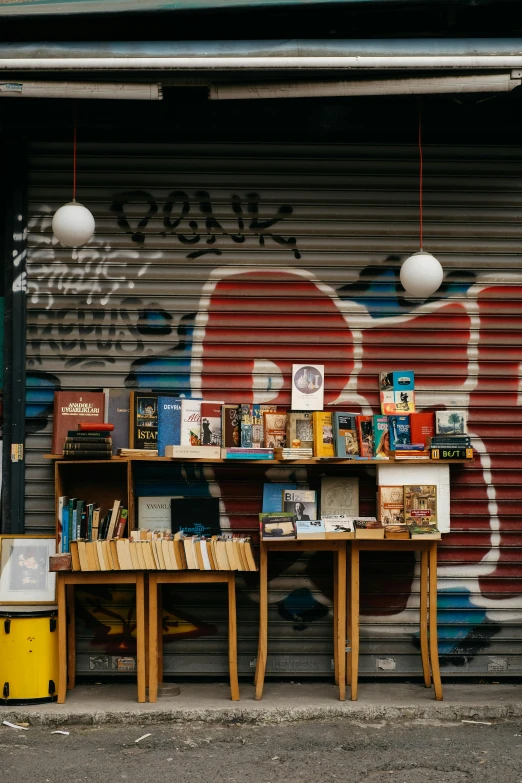 a couple of table with books on it sitting next to a building