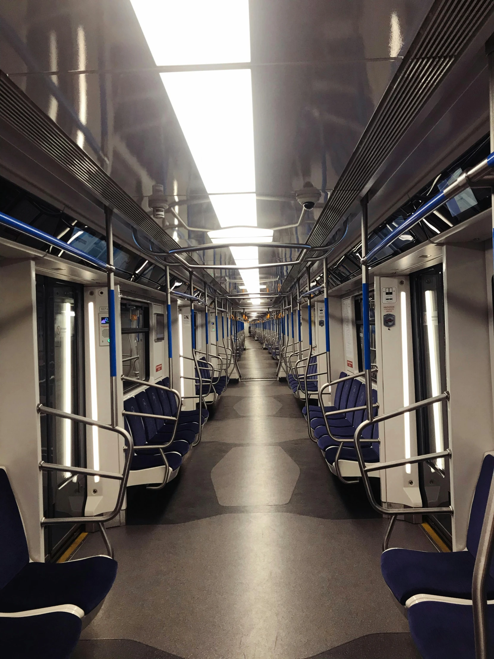 an empty train car with a lot of blue chairs