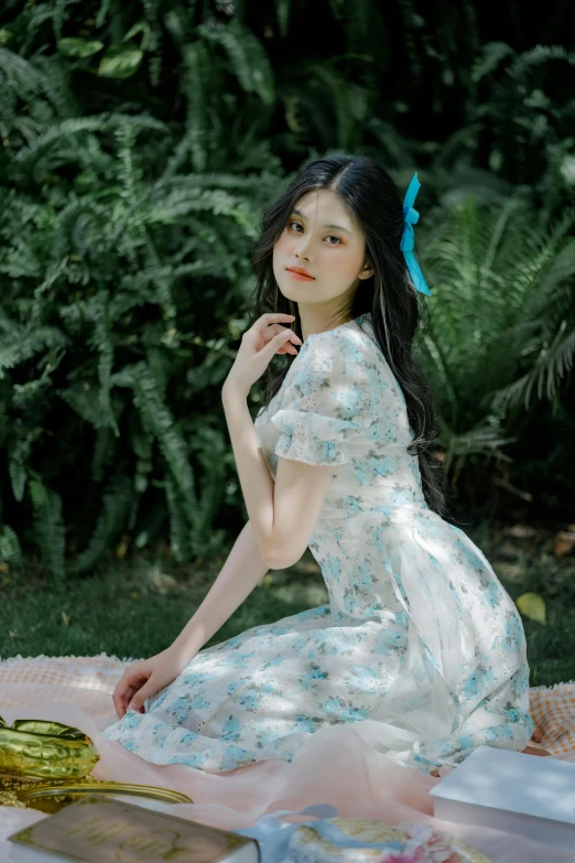 a girl is sitting on a towel in front of some trees