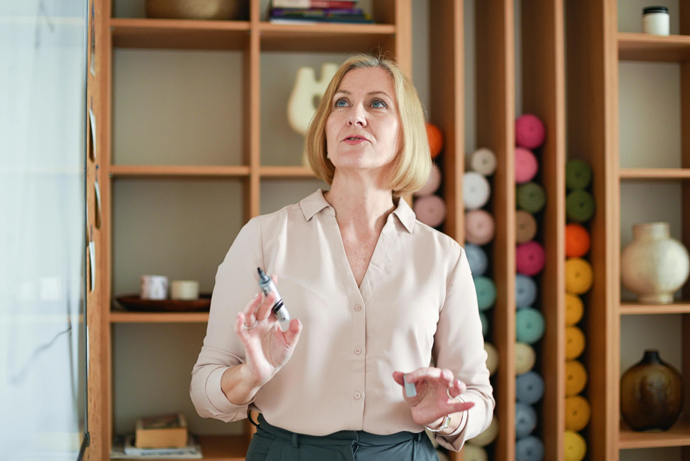 a woman standing in front of a wooden shelf