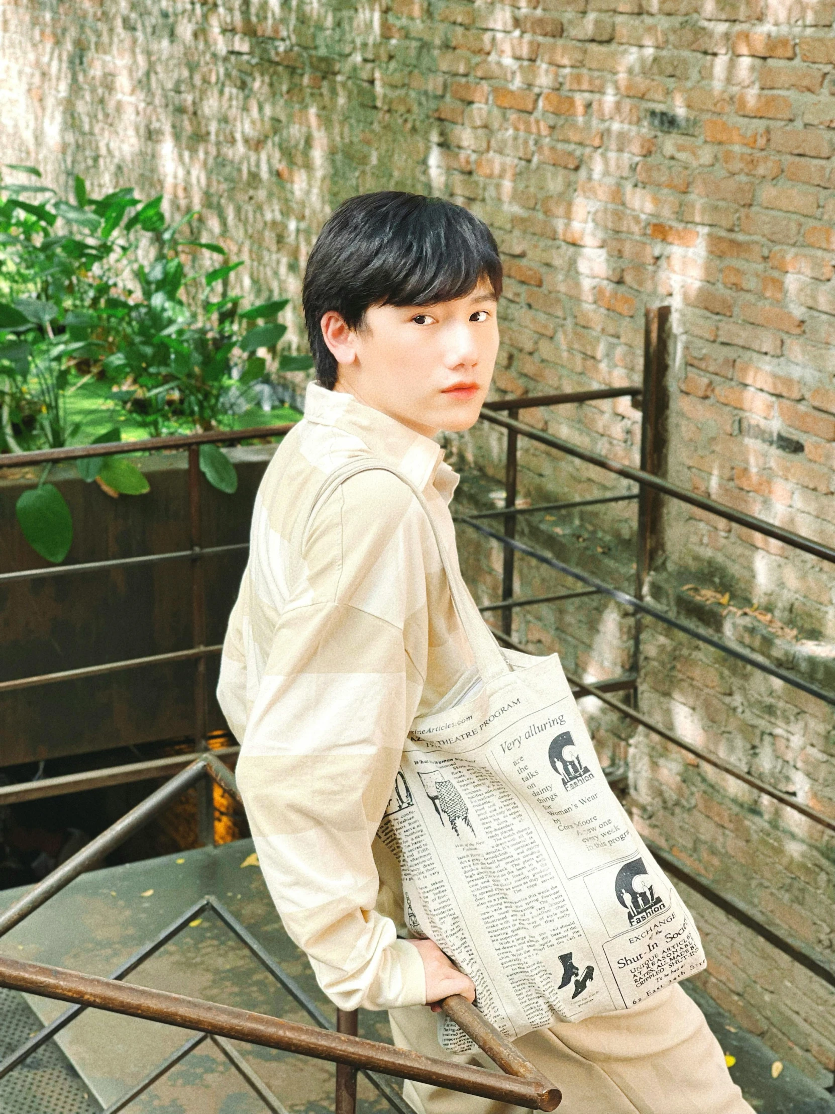 an asian man is sitting on a stair railing