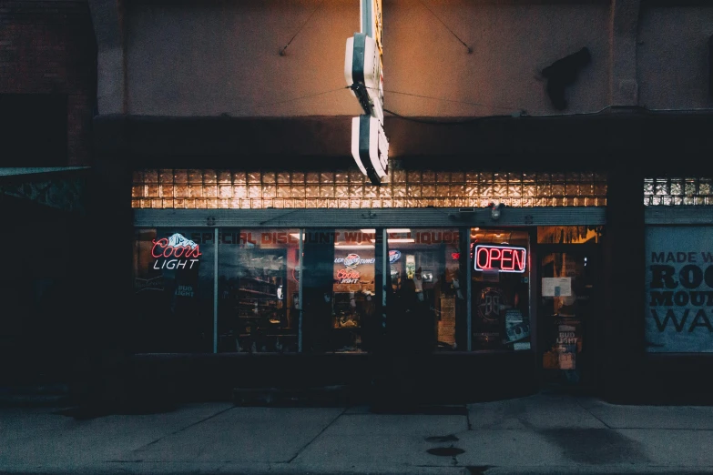 the front entrance to a bar with a lighted sign