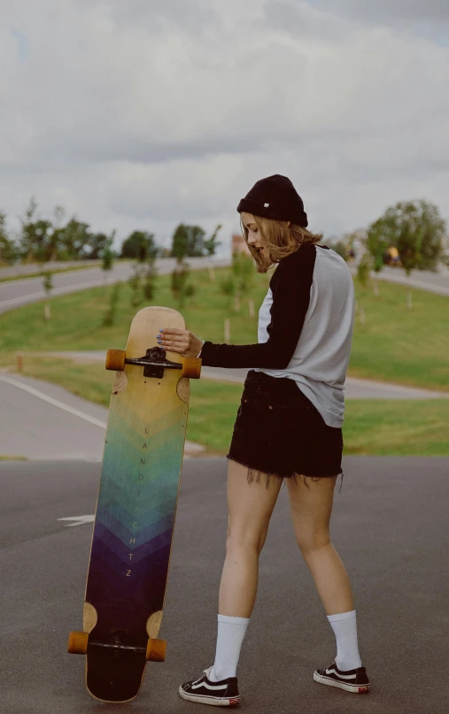 a person holding a skateboard while walking down a street